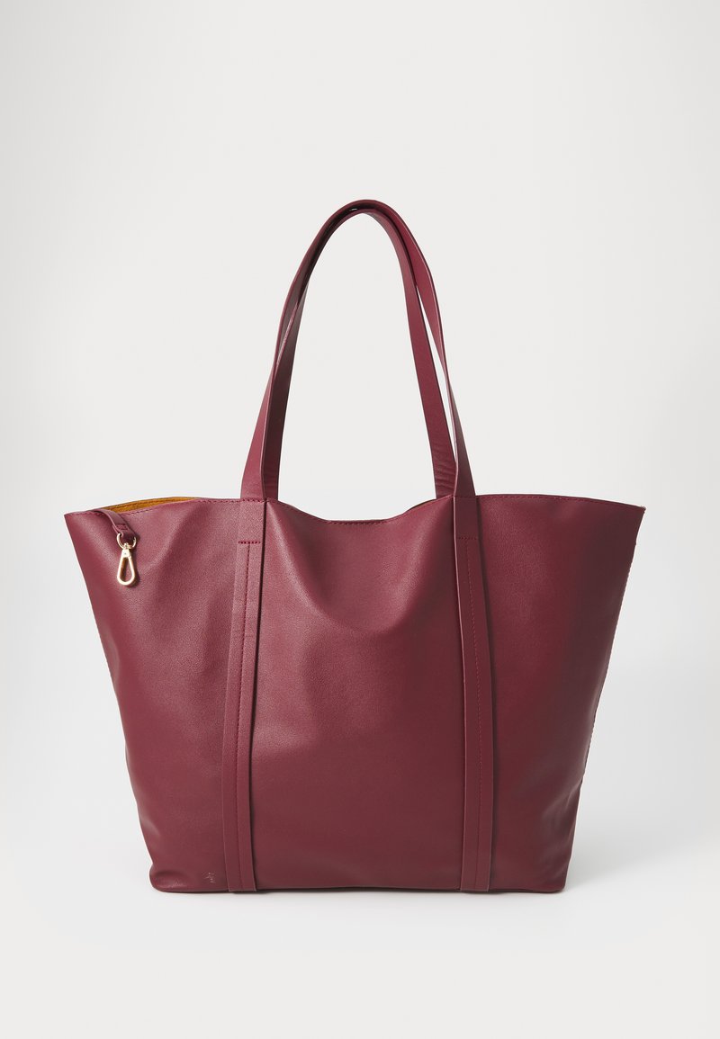 Maroon leather tote bag with two long handles, a rounded shape, visible stitching, and a gold hook accent near the opening.
