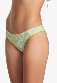 Bas de bikini dans des couleurs pastel avec un motif floral, présentant une texture côtelée et une coupe modérée pour une bonne couverture.