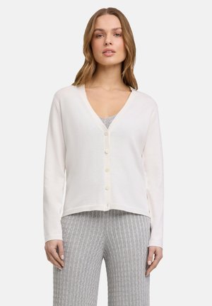 Witte, lange mouwen cardigan met een V-hals en knoopsluiting. Zachte textuur, korte ontwerp. Gedragen over een grijs geribbeld top en bijpassende broek.