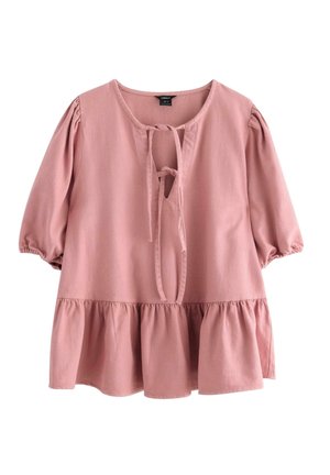 Blusa rosa pallido con maniche a sbuffo, scollatura a forma di V con nastri e orlo peplo svasato. Realizzata in tessuto morbido con una superficie testurizzata.