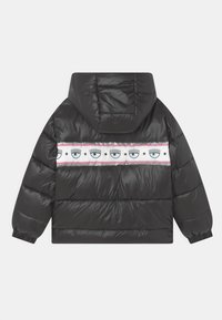 Černá prošívaná bunda s kapucí, s bílým proužkem s motivy očí a hvězd. Hladký, lesklý materiál s elastickými manžetami.