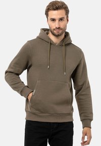 Khakifarbener Kapuzenpullover mit einer Fronttasche, Zugbandverschluss, gerippten Bündchen und Saum, aus einem strukturierten Baumwollmischgewebe.