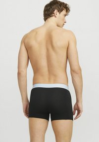 Fekete boxer alsónadrág, puha anyagból készült, világoskék derékrésszel. A szabás testhez simuló, a comb közepéig ér, sima textúrával.