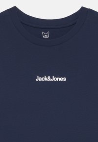 Camiseta de algodón azul marino con cuello redondo, que presenta un pequeño logo blanco "Jack&Jones" impreso en el pecho y una etiqueta con el logo en el interior del cuello.