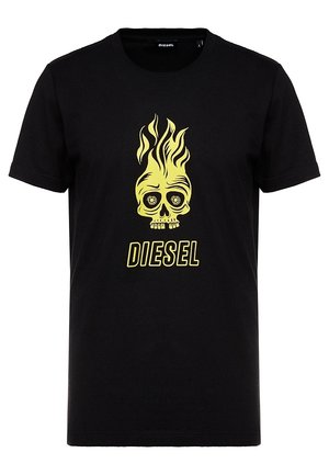 T-shirt noir à manches courtes avec un graphisme de crâne jaune enflammé et le texte "DIESEL" centré à l'avant.