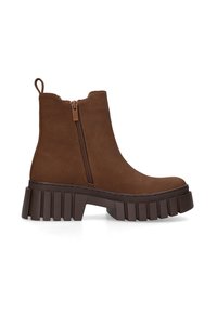 Braune Wildleder-Ankle Boots mit einem seitlichen Reißverschluss, runder Zehenpartie und einer dicken, strukturierten Plateausohle. Mit einer Schlaufe zum einfachen Anziehen.