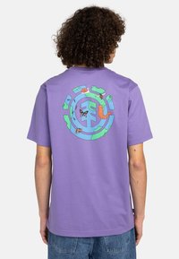 Camiseta de algodón morada con un gráfico colorido de insectos y un caracol dentro de un diseño circular en la parte posterior. Mangas cortas, ajuste casual.