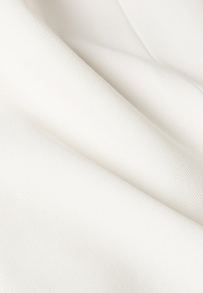 Biała tkanina z delikatną pionową żebrowaną fakturą, pokazana w miękkich fałdach i zbliżeniu.