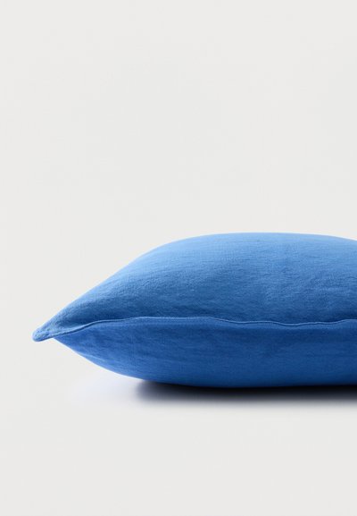 Kék téglalap alakú szövetpárna, oldalnézetben, egyszínű fehér háttér előtt.