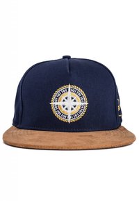 Navy blue cap with a tan suede brim, featuring a white and gold embroidered compass design at the front and a gold accent on the side.