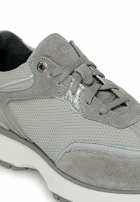 Grauer Sneaker mit einem Mesh-Obermaterial und Wildlederakzenten, strukturierten Details, tonalen Schnürsenkeln und einer Gummisohle für bessere Traktion.