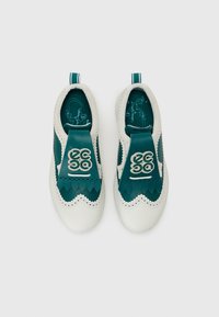 Baskets slip-on blanches et teal avec un design en forme de vagues, des accents perforés et un revêtement en tissu texturé. Semelles intérieures vertes avec des détails graphiques.