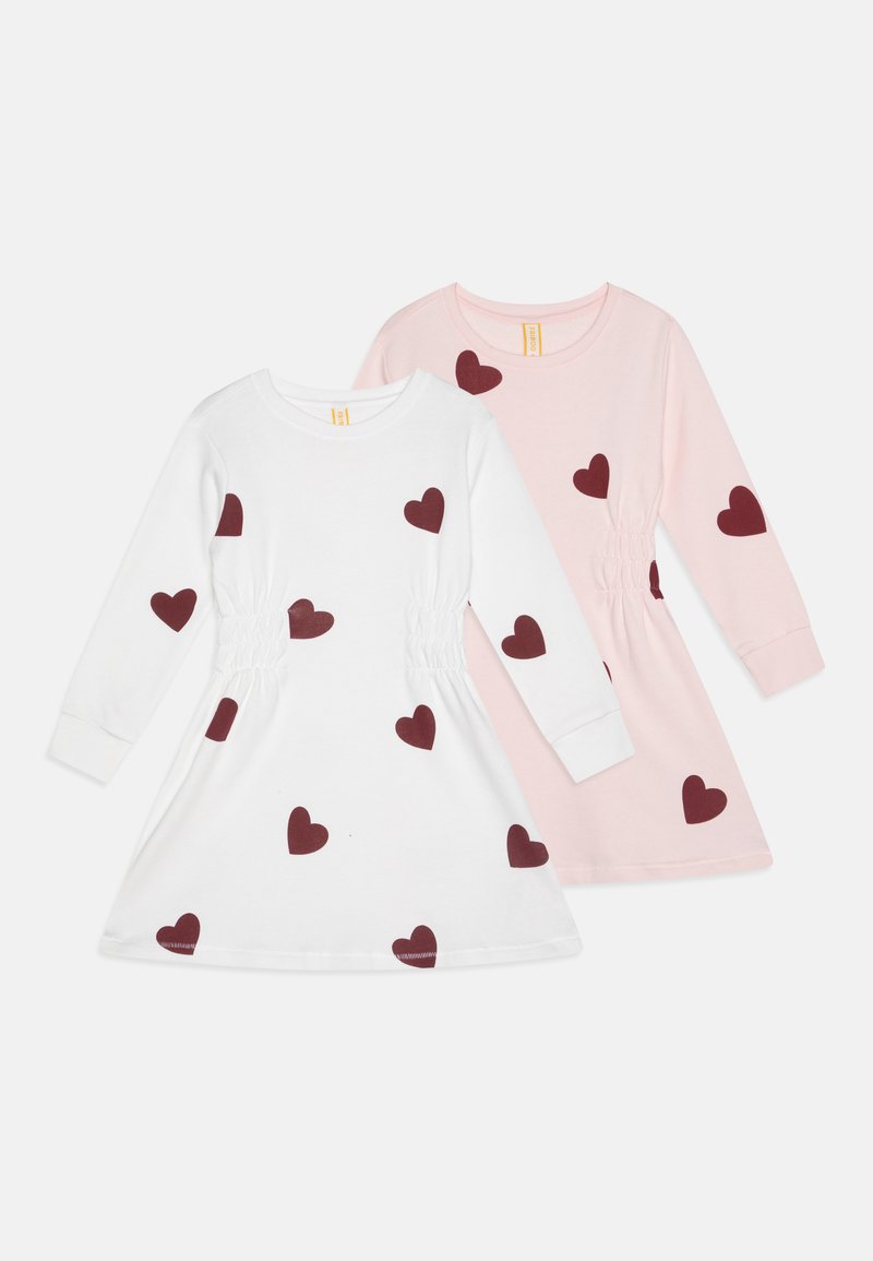 Kaksi pitkähihaista mekkoa. Toinen valkoinen, jossa on burgundinvärisiä sydäntulosteita ja kerättyjä sivuja; toinen vaaleanpunainen, jossa on samankaltaisia sydäntimekkoja. Pehmeä puuvillakangas.