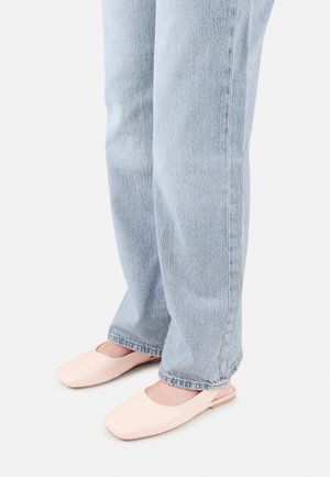 Jasnoróżowe klapki open-back z kwadratowym noskiem, zestawione z jasnoniebieskimi jeansami o prostych nogawkach. Klapki mają gładką fakturę i minimalistyczny design.