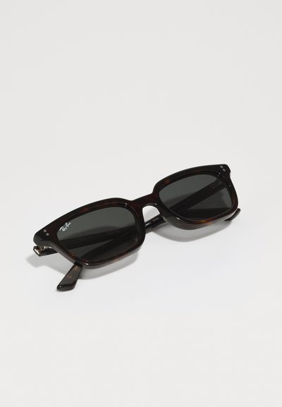 Lunettes de soleil Ray-Ban avec une monture en plastique écaille de tortue, verres noirs, forme rectangulaire, branches larges et détail du logo près du verre.