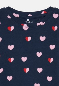 Königsblaues Kurzarmhemd mit einem Muster aus rosa und roten Herzformen, aus glattem Baumwollmaterial und mit klassischem Rundhalsausschnitt.