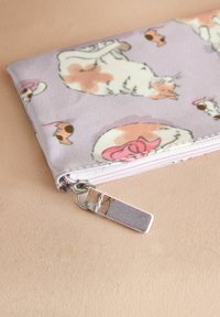 Pochette rettangolare in tessuto lavanda, con stampa di gatti. Ha una chiusura con zip e un tirante argentato, e presenta una superficie texture.