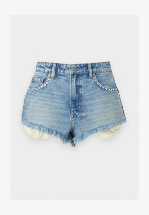 Lyseblå denimshorts med flossede kanter, rhinsten-detaljer langs forlommerne og udsat inderlag af hvidt stof.