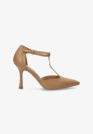 Zapato de tacón desnudo con puntera afilada, diseño de tira en T, material sintético suave y un delgado tacón stiletto.