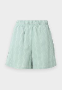 Shorts texturés vert clair avec une taille élastique et un motif en zigzag. Dotés de fentes latérales pour plus de confort et de circulation de l'air.
