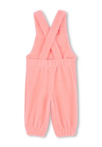 Salopette en polaire rose avec des bretelles croisées, taille élastique et poignets de jambes élastiqués. Texture douce avec des accents en forme de nuage sur les bretelles.