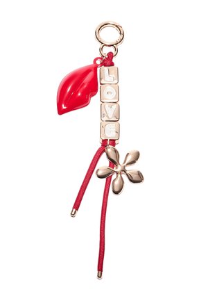Roter Schlüsselanhänger mit glänzendem Blatt, goldenen "LOVE"-Buchstaben und einem goldenen Blumenakzent an einer roten Schnur. Verfügt über einen runden Metallring.