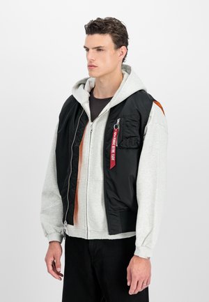 Black and gray hooded jacket with a zip front, featuring a patch pocket, red tag detail, and contrast brown panel on the side.
