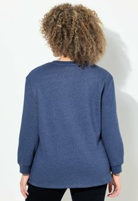 Sweat-shirt bleu marine, manches longues, col rond, texture douce, coupe décontractée, avec des poignets et un ourlet côtelés, design uni, sans motifs visibles.