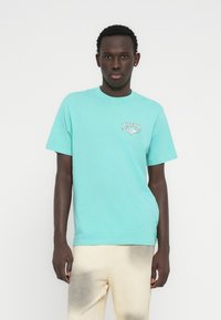 Ανοιχτό τιρκουάζ βαμβακερό t-shirt με μικρό λογότυπο Rip Curl στο αριστερό στήθος. Κοντά μανίκια και στρογγυλή λαιμόκοψη, με λεία υφή.