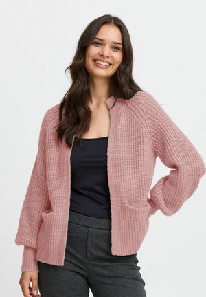 Cardigan rosa a maglia con un motivo testurizzato, apertura frontale, due tasche e maniche lunghe. Indossato sopra un top scuro, con una vestibilità comoda.