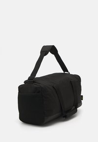 Black duffel bag with a zippered closure, textured mesh side panel, padded handles, and a smooth bottom surface. Compact and functional design.