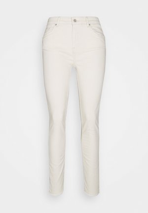Jean slim taille haute de couleur blanc cassé avec bouton sur le devant, fermeture éclair, et design à cinq poches, présenté sur un fond blanc.