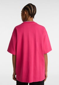 Overdimensioneret T-shirt med korte ærmer i lys pink bomuld, med en rund halsudskæring og uden synlige mønstre eller detaljer.