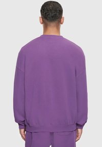 Lila Sweatshirt mit Rundhalsausschnitt, lockerer Passform und gerippten Bündchen. Glatte Textur und einfarbig, ohne sichtbare Muster oder Logos.