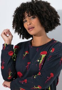 Suéter negro con estampados de medusas coloridas en rojo, verde y púrpura. Tela suave con cuello redondo y mangas largas.