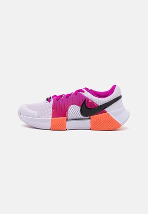 Scarpe sportive con tomaia in mesh bianco, dettagli rosa, logo swoosh nero e suola in gomma arancione con motivo testurizzato.