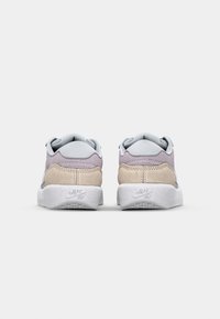 Sneaker con una parte superiore in morbido suede grigio e beige, colletto imbottito e suola in gomma bianca con un motivo testurizzato.