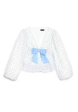 Blouse blanche à manches longues avec des pois bleu clair, un col en V profond, des manches bouffantes et un grand nœud bleu clair au centre avant.