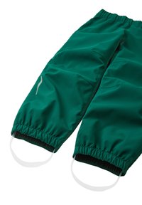 Grønne vandtætte bukser lavet af glat, fleksibelt materiale. Har elastisk talje, elastiske mansjetter og reflekterende logo-detaljer.