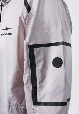 Manica di giacca grigia chiara con zip nera, strisce nere orizzontali e patch rotondo con logo PXP nero sulla parte superiore del braccio.