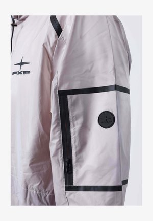 Manica di giacca grigia chiara con zip nera, strisce nere orizzontali e patch rotondo con logo PXP nero sulla parte superiore del braccio.