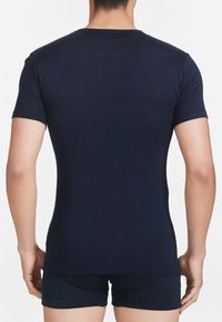 T-shirt a maniche corte blu navy, dal design aderente e realizzato in tessuto morbido, con collo a giro e dettagli di cucitura minimi.