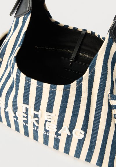 Τσάντα ώμου με κάθετες ρίγες σε μπλε και λευκό, με το λευκό κείμενο «THE TIEKS BAG» και μαύρο εσωτερικό με τσεπάκι με φερμουάρ.