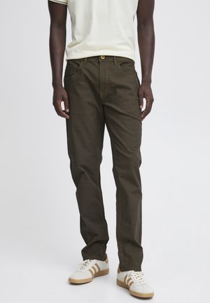 Pantalones de color verde oliva oscuro hechos de una tela texturizada, con un corte regular, cinco bolsillos y costuras en amarillo contrastante.