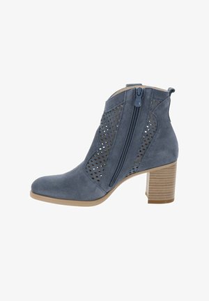 Stivaletto alla caviglia in pelle scamosciata blu con pannelli laterali traforati, chiusura con zip e tacco a blocco impilato, mostrato di profilo.
