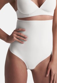Hoge witte shapewear met een glad, naadloos ontwerp. Zachte stof, geen zichtbare naden en een strakke pasvorm voor ondersteuning en vormgeving.