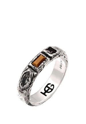 Silberner strukturierter Ring mit drei Edelsteinen: schwarzer Oval, rechteckiger Bernstein und quadratischer dunkelvioletter, mit "JG 925" innen im Ring graviert.