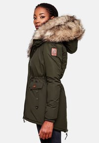 Parka acolchada verde oliva con capucha de piel sintética, cinturilla ajustable, bolsillos con botón y puños elásticos. Presenta un parche con el logo en la manga.