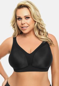 Svart trådlös bh med breda remmar, V-urringning, slät tyg och ventilerande meshnät. Har minimala sömmar för komfort.
