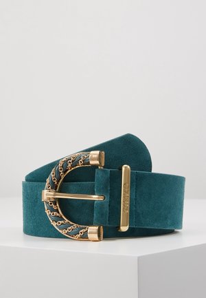 Pasek zamszowy w kolorze zielonkawoniebieskim z klamrą ozdobioną złotym łańcuszkiem i złotym uchwytem z wygrawerowanym napisem "PINKO", prezentowany na białej powierzchni.